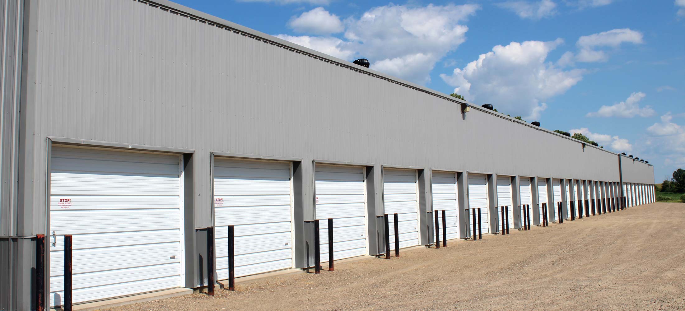 Row of overhead garage doors at Strack's Self Storage in Randall, MN