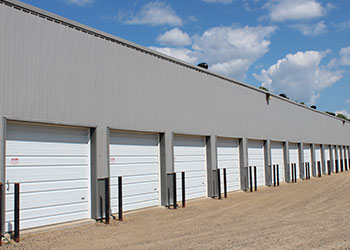 Row of overhead garage doors at Strack's Self Storage in Randall, MN